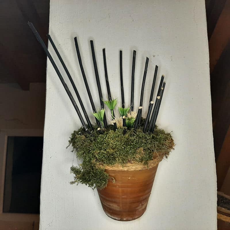 On découvre un pot a l'intérieur duquel viennent se planter des bâtons plus ou moins long qui donne du relief a ce bouquet